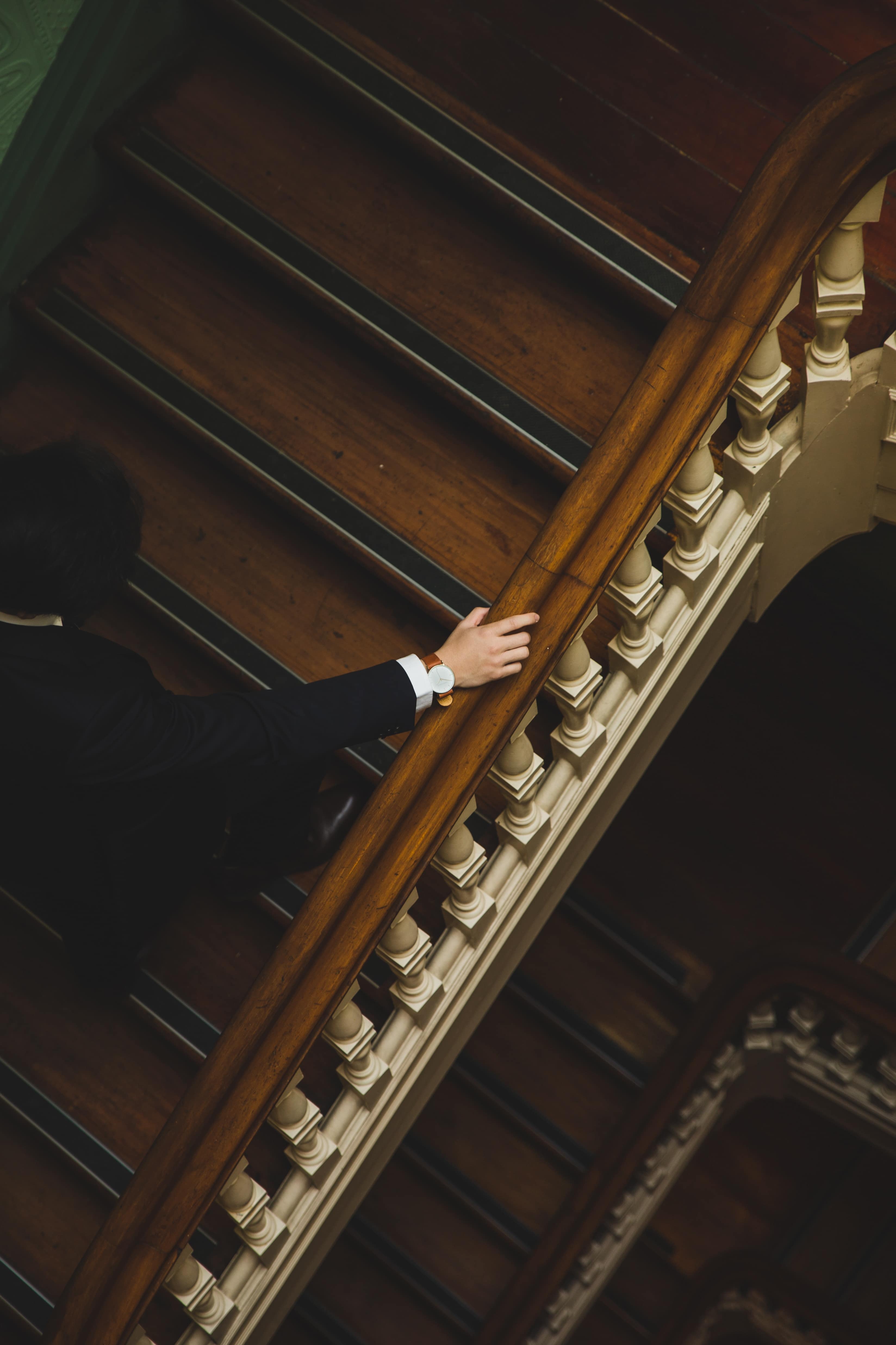 Homme en costume portant une montre et montant les escaliers